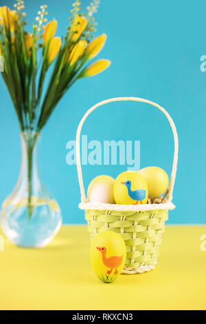 Easter basket with eggs on yellow background. Stock Photo