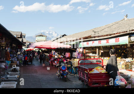 Zhongyi food and vegetable market with Jade Dragon Snow mountain in the background, Lijiang, Yunnan, China Stock Photo