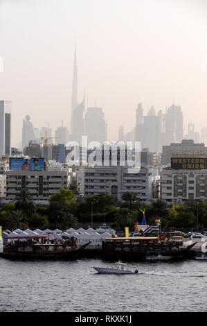 Skyline of Downtown Dubai with its high raised towers including the tallest, the Burj Khalifa, surrounded in the late afternoon heat haze from the Dub Stock Photo