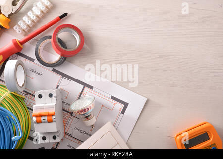 Equipment on white wooden table for electrical installation of housing with space on the right. Horizontal composition. Top view. Stock Photo