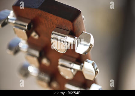 Guitar mechanism. Guitar headstock with focus on string winding mechanism: pegs, strings, vulture. Musical instruments. Music concept. Stock Photo