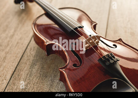 Close up view of beautiful classical violin lying on wooden background. Musical instruments. Music equipment. Music background Stock Photo