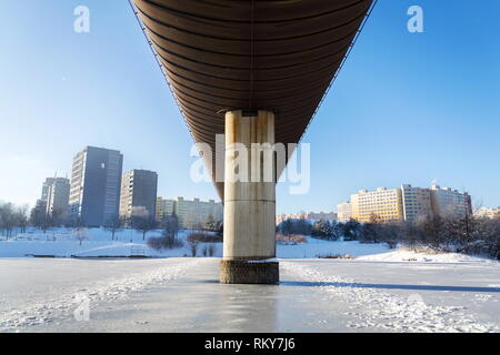 Subway overground tunnel passing over frozen pond, sunny winter freezing day, Prague between metro stations Hurka and Luziny, Czech Republic Stock Photo