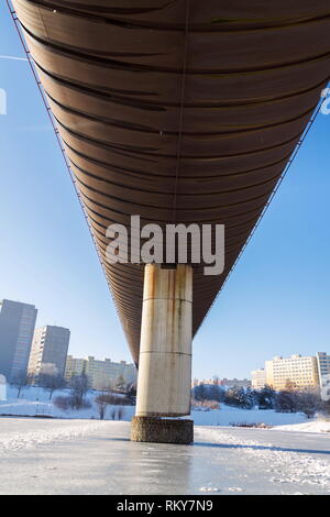 Subway overground tunnel passing over frozen pond, sunny winter freezing day, Prague between metro stations Hurka and Luziny, Czech Republic Stock Photo