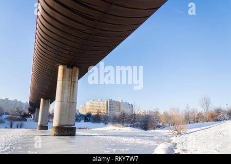 Subway overground tunnel passing over frozen pond, sunny winter freezing day, Prague between metro stations Hurka and Luziny, Czech Republic Stock Photo