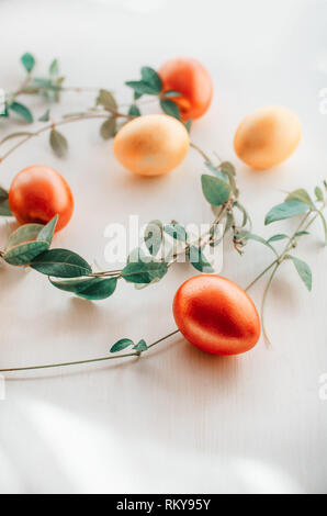 Multi-colored eggs on a white background. Creative Easter concept. Living coral - the color of the year 2019 Stock Photo
