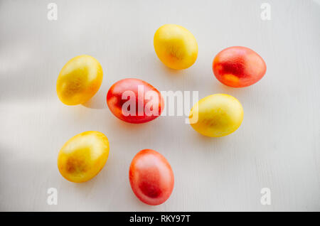 Multi-colored eggs on a white background. Creative Easter concept. Living coral - the color of the year 2019. Stock Photo