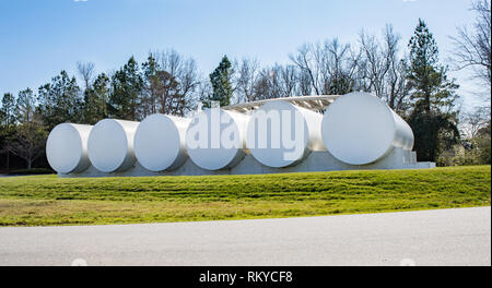 6 large tanks at a depot filling station with bright blue sky and green grass. Stock Photo