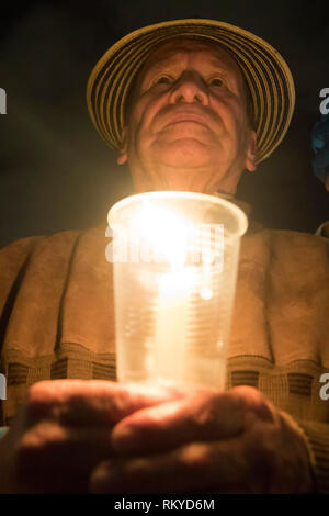 Senior holding candle.  On July 6, 2018, a vigil was held in 25 cities of Colombia and the world as a form of protest for the murder of social leaders Stock Photo