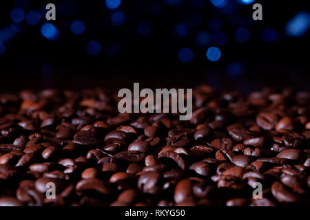 A pile of roasted coffee beans with blue bokek background. Stock Photo