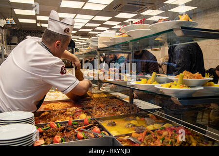 Men queue up for lunch in a Turkish self service restaurant. Stock Photo