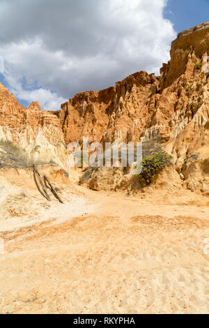 High cliffs along Falesia Beach and The Atlantic Ocean in Albufeira, Algarve, Portugal. Sunny summer day, blue sky with stormy clouds. Stock Photo