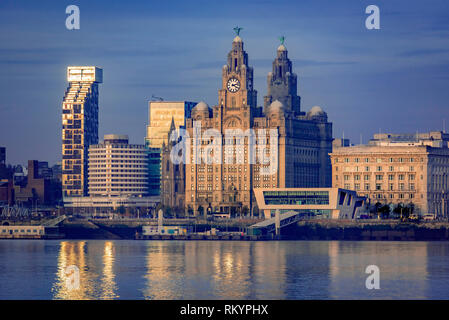 Liverpool waterfront reflecting in the early autumn sunshine on a calm river Mersey. Merseyside North West England. Stock Photo