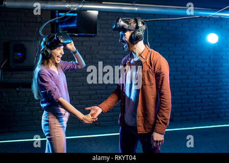 Man and woman shaking hands before the game in virtual reality standing together in the playing club Stock Photo