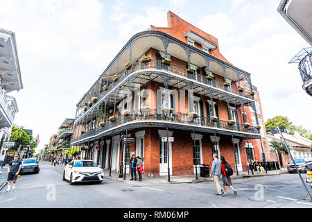 New Orleans, USA - April 23, 2018: Old town Royal street corner building in Louisiana famous city shops in evening with cast iron balconies and flower Stock Photo