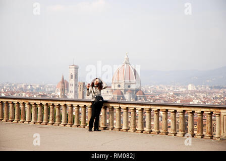tourist admires view of florence city from piazzale michelangelo terrace tuscany italy 2018 Stock Photo