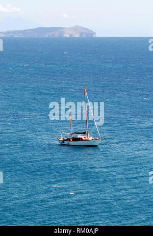 twin-shaft sail boat yacht enjoy the sea stopping quiet at anchor in the middle of the sea with the palinurus head in the background near cilento coas Stock Photo