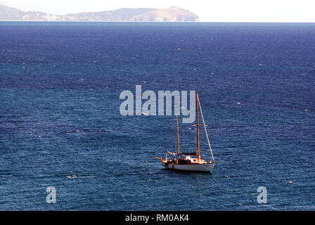 twin-shaft sail boat yacht enjoy the sea stopping quiet at anchor in the middle of the sea with the palinurus head in the background near cilento coas Stock Photo