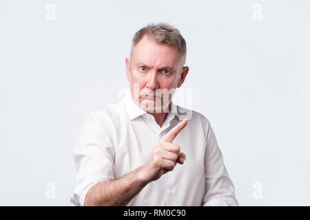 Strict senior man showing index fingers up, giving advice Stock Photo