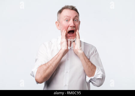senior european man in white shirt shout something Stock Photo