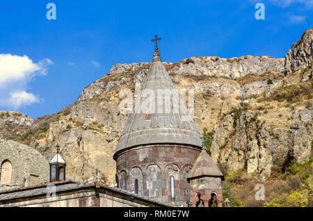 View of all domes with crosses and a cave church with carved khachkars on the walls, in the Geghard monastery in Armenia Stock Photo