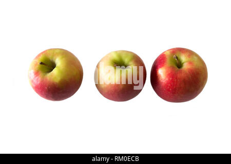 Three whole red and green apples in a row on a white background in studio Stock Photo