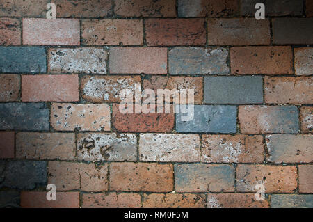 Multi-colored brick work texture lit diagonally Stock Photo