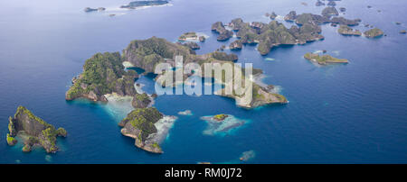 Limestone islands lie scattered about the seascape in Raja Ampat, Indonesia. This remote, tropical region is known for its marine biodiversity. Stock Photo