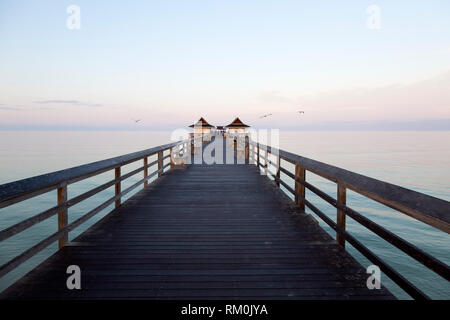 View down the Old Naples pier in Florida, the the USA. People gather at the end of the pier to socialize. Stock Photo