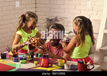 halloween family of man and girls in paint with pumpkin Stock Photo