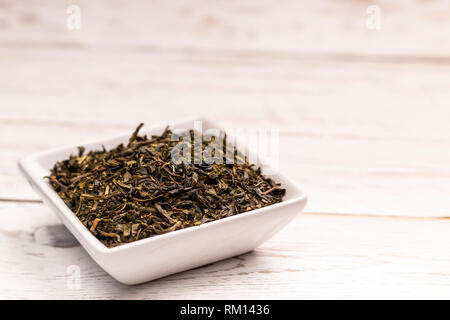 Close-up view of dry moroccan mint tea leaves with in small white ceramic plate on white table Stock Photo