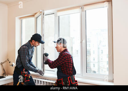 Quality light. Construction workers installing new window in house together Stock Photo