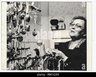 THE CZECHOSLOVAK SOCIALIST REPUBLIC - CIRCA 1960s: Retro photo shows woman and christmas tree. Black white photography. 1960s Stock Photo