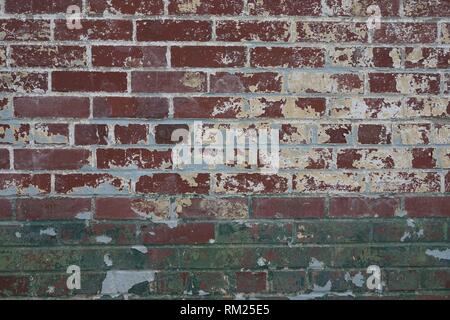 Closeup surface pattern of an old brick wall with green grey and yellow paint textured background Stock Photo