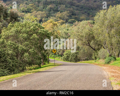 Rural country road in Australia, with a kangaroo traffic warning sign. Stock Photo