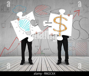 Two men connecting puzzles for idea is money concept on wooden floor Stock Photo
