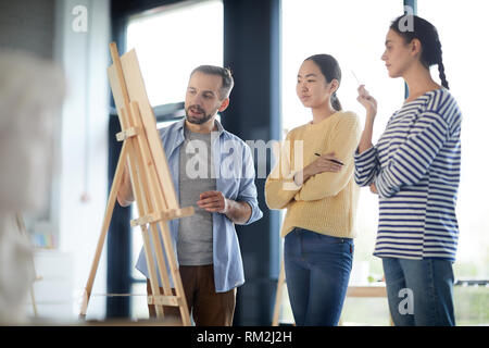Students and teacher by easel Stock Photo