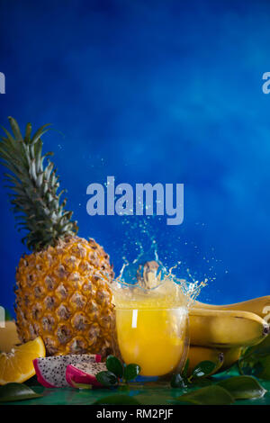 Fresh juice dynamic splash. Tropical fruits, bananas, pineapple, and dragon fruit. Exotic drink action photography with copy space Stock Photo