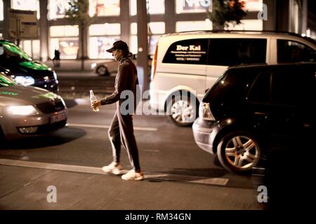 woman walking with bottle on street in Berlin, Germany