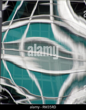 close up of silver and green fluid abstract pattern on glass Stock Photo