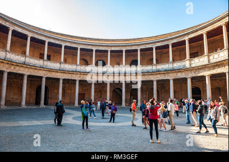 Tourists inside the Palacio de Carlos V at the Alhambra, a 13th century Moorish palace complex in Granada, Spain. Built on Roman ruins, the Alhambra w Stock Photo