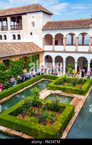 Tourists in the Generalife, or summer palace, at the Alhambra, a 13th century Moorish palace complex in Granada, Spain. Built on Roman ruins, the Alha Stock Photo