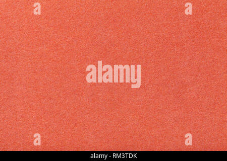 Dark orange matte background of suede fabric, closeup. Velvet texture of seamless red woolen felt. Stock Photo