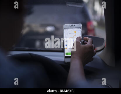 Dki Jakarta, DKI Jakarta, Indonesia. 13th Feb, 2019. An on-line taxi driver seen using gps navigate which was mounted above the car dashboard to provide driving direction at Jakarta, Indonesia.Indonesian Constitutional Court has ruled that checking the GPS on a mobile phone while driving is punishable by up to three months' imprisonment, as stipulated in the 2009 Traffic Law. Credit: Agung Fatma Putra/SOPA Images/ZUMA Wire/Alamy Live News Stock Photo