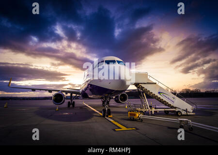 Aeroplane waiting for passengers to board on the apron at Gatwick Airport in the UK, at dusk. Stock Photo