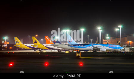 Aircraft lined up on the apron of Gatwick Airport at night, U.K. Stock Photo