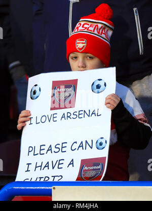 A young Arsenal fan holds a banner in the stands Stock Photo