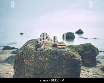 Detailed pile of stacked stones on the beach. Huge amount of zen stones pyramids in the beach Stock Photo
