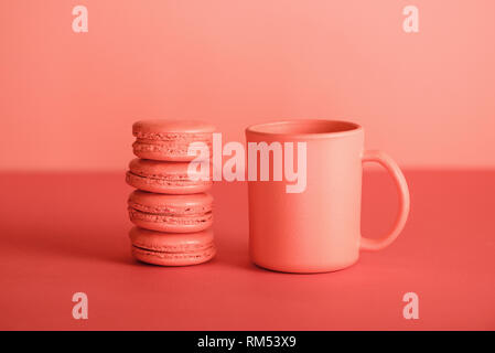 cup and macaroons in Living coral color. Pantone color of the year 2019 concept Stock Photo