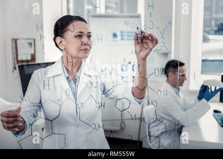 Scientist is making notes on the glass board Stock Photo